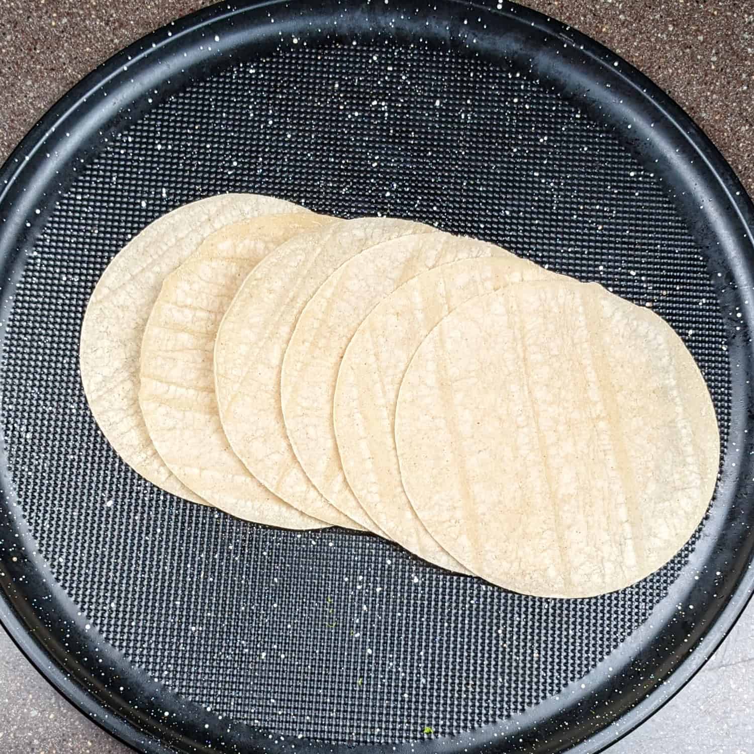 corn tortillas cascaded in a round tray.
